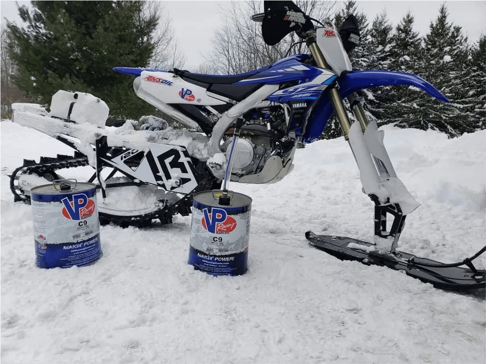 Blue Yamaha dirt bike with VP Racing Fuel cans in snow