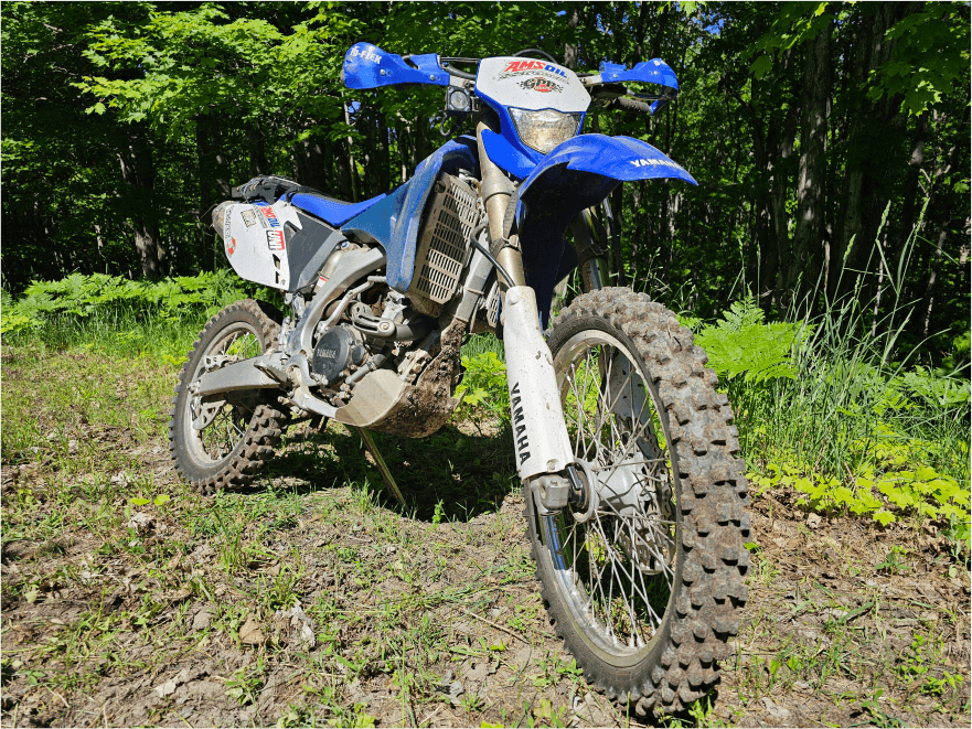 Blue Yamaha dirt bike on a forest trail