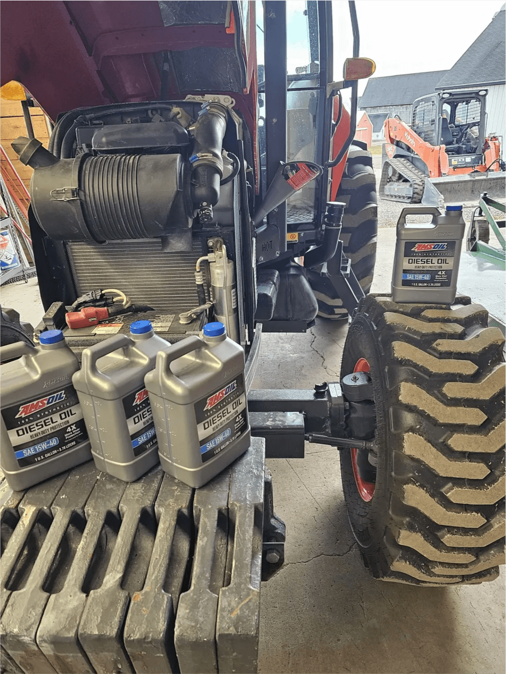AMSOIL Heavy-Duty Diesel Oil containers next to a Kubota tractor engine